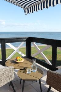 un tavolo e sedie su un balcone con vista sull'oceano di Prie Mariu a Nida