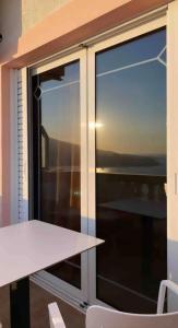 een tafel en stoelen voor een groot raam bij Sea View Studios and Apartments Vila Tani-2 in Sarandë