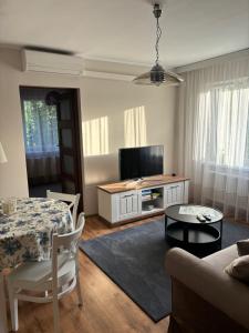 a living room with a table and a television at Raj z haczykiem in Grzmięca