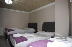 een hotelkamer met drie bedden en handdoeken erop bij Kümbet Hotel in Istanbul