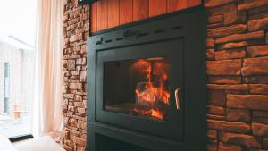 Una chimenea de ladrillo con fuego en ella en RentUp - Experimenta la belleza de San Martin de los Andes, en San Martín de los Andes