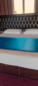 1 cama con marco negro y colchón azul en Desert heart camp en Wadi Rum