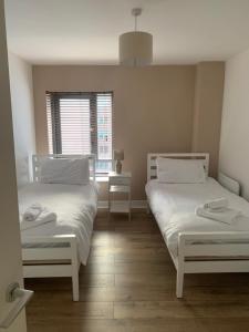 Un dormitorio con dos camas y una ventana. en Best Location in Belfast! Free parking, en Belfast