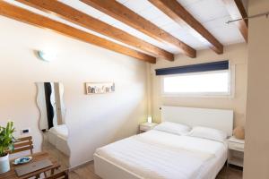 a bedroom with a white bed and a window at B&B Residenza Marina in Marina di Carrara