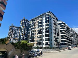 two tall apartment buildings with cars parked in front of them at SA Apartments! Mahmutlar, 300m to the Beach in Alanya