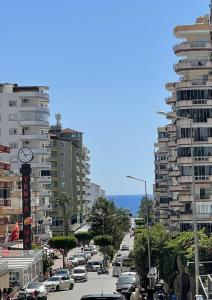 a busy city street with parked cars and a clock at SA Apartments! Mahmutlar, 300m to the Beach in Alanya