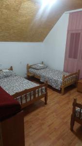2 Betten in einem Zimmer mit Holzböden in der Unterkunft Etno selo Šapat in Šavnik