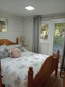 馬漢萊斯的住宿－Comfy Secluded Cabin，一间卧室配有一张带粉红色枕头的床