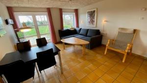 ein Wohnzimmer mit Sofa und Tisch in der Unterkunft Læsø Efterskole in Læsø