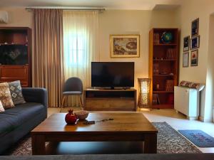 a living room with a couch and a tv at Eleni's Holiday Home in Kalamata