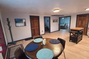 a dining room with a table and chairs and a piano at The Northern Lights Cottage in Columbia Falls