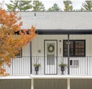 una casa blanca con una valla delante en Lakefront Bubbles & Beach, en Flat Rock