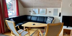 - un salon avec un canapé, une table et des chaises dans l'établissement Læsø Efterskole, à Læsø