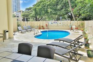 a patio with chairs and a small swimming pool at Aqua Aloha Surf Waikiki in Honolulu