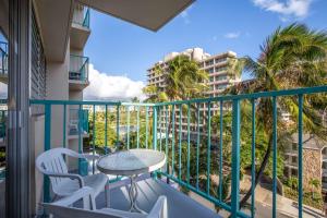檀香山的住宿－威基基阿瓜阿洛哈衝浪酒店，阳台配有桌椅和棕榈树。