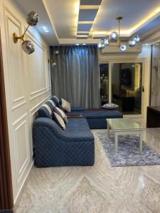 uma sala de estar com um sofá azul e uma mesa em Join Inn Apartments em Alexandria