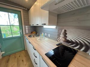 a small kitchen with a stove and a sink at La Bohème in Merendree