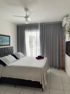 1 dormitorio con 1 cama y ventilador de techo en Casa Estelar, en Cabo Frío
