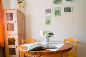 蘇瓦烏基的住宿－Wigierska Zagroda - agroturystyka，一张桌子,上面有一本书和一个花瓶
