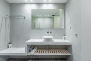 Baño blanco con lavabo y espejo en Sampatiki Suites - 4 Star Seaview Luxury Suites With Breakfast And Spa - Opened 2024, en Leonidio