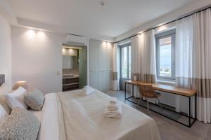 Habitación de hotel con cama, escritorio y ventana en Sampatiki Suites - 4 Star Seaview Luxury Suites With Breakfast And Spa - Opened 2024, en Leonidio