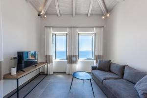 sala de estar con sofá y TV en Sampatiki Suites - 4 Star Seaview Luxury Suites With Breakfast And Spa - Opened 2024, en Leonidio