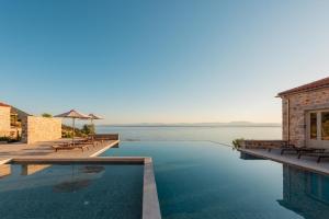 uma piscina com vista para a água em Sampatiki Suites - 4 Star Seaview Luxury Suites With Breakfast And Spa - Opened 2024 em Leonidio