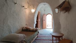 - un couloir avec un lit et une table dans une chambre dans l'établissement Gite Douiret, à Ad Duwayrāt