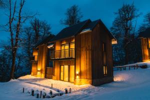 una baita di tronchi nella neve di notte di RentUp - Lujo en la naturaleza a San Martín de los Andes