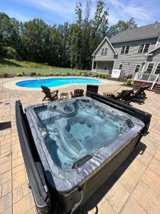 a hot tub in the middle of a yard at 9 Bedroom Saratoga Retreat, Heated Pool, HotTub, Firepit, Creek, Mini Golf On 10 Acres! in Saratoga Springs