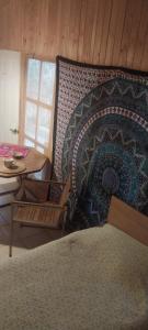 1 dormitorio con cama, mesa y almohada en Hostal Acuariano Piscoelqui, en Pisco Elqui