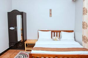 a bedroom with a bed and a table and a mirror at Mesuma Hotel Dodoma in Dodoma