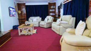 een woonkamer met witte meubels en een rode loper bij Vimbainashe Villas 