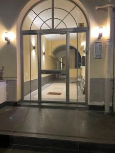 una entrada a un pasillo con una puerta de cristal en 4 Giornate Apartment en Nápoles
