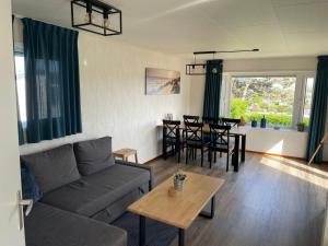 ein Wohnzimmer mit einem Sofa und einem Tisch in der Unterkunft Blauwe Zeedistel in IJmuiden