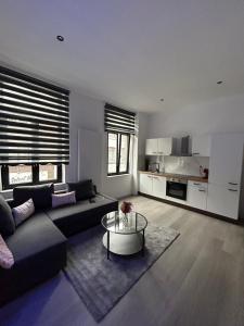 a living room with a couch and a table at FourSuites Liège in Liège