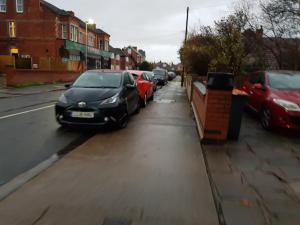 een rij auto's geparkeerd aan de kant van een straat bij Fairhaven Guest Accommodation in Nottingham