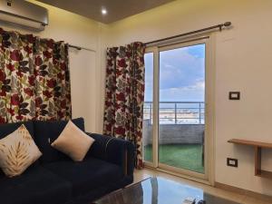 een woonkamer met een bank en uitzicht op de oceaan bij Join Inn Apartments in Alexandrië