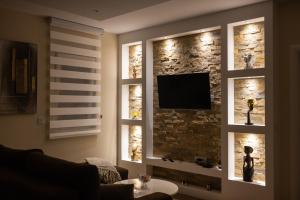 a living room with a tv on a brick wall at Javorov list LUX in Šabac