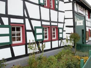 a half timbered house with red and green windows at Nostalgic apartment in the Eifel region in Schleiden