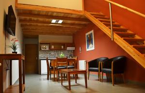 sala de estar con mesa y sillas y escalera en Centro Apart en Villa Elisa