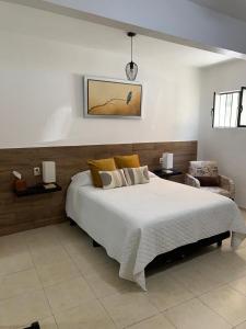 a bedroom with a large white bed and a chair at Casa Don Agus in Guanajuato