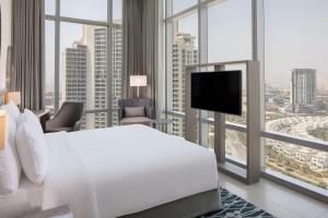 Habitación de hotel con cama y TV de pantalla plana. en The First Collection at Jumeirah Village Circle, a Tribute Portfolio Hotel en Dubái