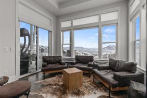 a living room with leather furniture and large windows at Deer Springs 12797 by Moose Management in Park City