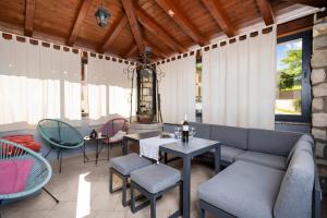 un patio con sofá, mesas y sillas en Holiday Home Regina, en Kršan
