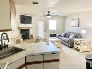 eine Küche und ein Wohnzimmer mit einem Sofa und einem Tisch in der Unterkunft Dells Suite Dreams At Lighthouse Cove Condominiums in Wisconsin Dells
