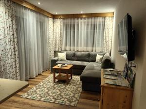 a living room with a couch and a tv at Ferienwohnungen Meister in Hinterhornbach
