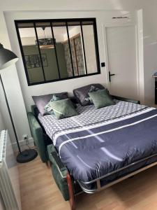 a bedroom with a bed with pillows and a mirror at Le soleil levant plage , casino, thalasso in Bénodet