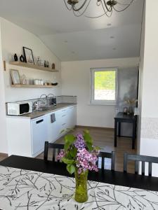 Vila Trakai في تراكي: مطبخ وغرفة طعام مع إناء من الزهور على طاولة