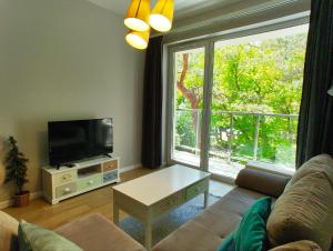 ein Wohnzimmer mit einem Sofa und einem TV in der Unterkunft Dwie sosny i świerk in Ustronie Morskie